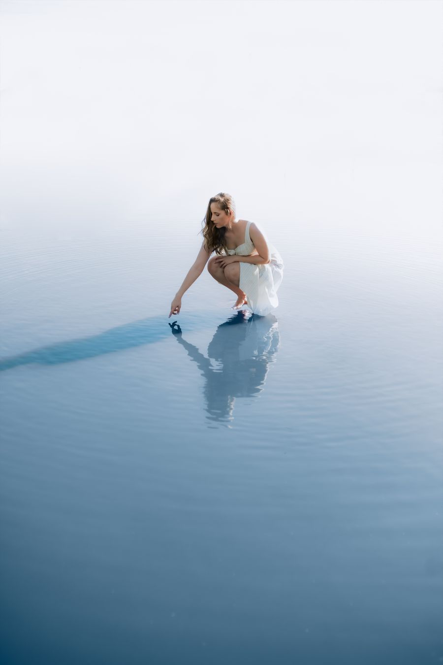 Bride in a white gown by the lake